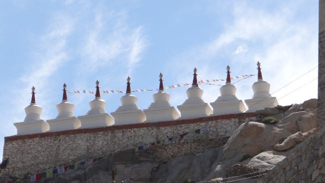 Rangées de petits dômes avec des drapeaux de prières bouddhistes sur fond de ciel bleu